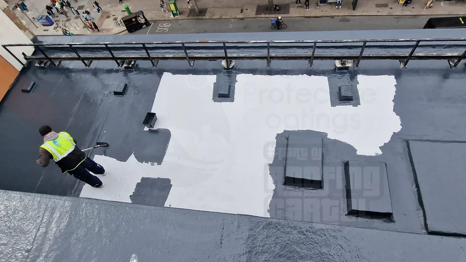 Professional applicator applying LAVA 20 liquid waterproofing topcoat over reinforcement on a flat roof