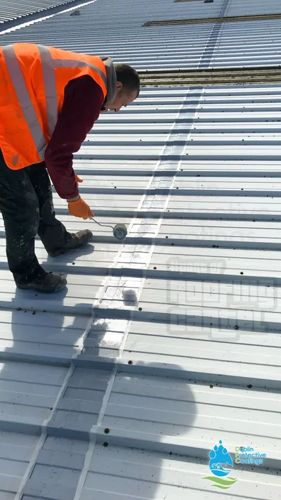 Professional applying cut-edge corrosion treatment on metal roof