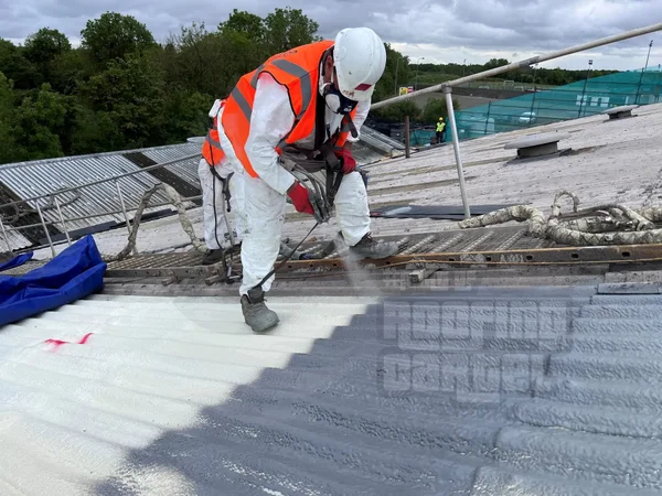Spraying polyurea coating on asbestos cement roof for safe encapsulation